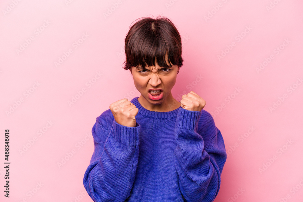 Young hispanic woman isolated on pink background upset screaming with tense hands. Young hispanic woman isolated on pink background upset screaming with tense hands.
