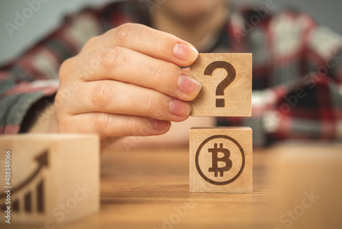 Bitcoin and question mark symbols on a wooden cubes. Concept of FAQ, ideas of investment and business plans