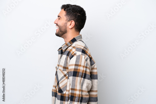 Young Brazilian man isolated on white background laughing in lateral position