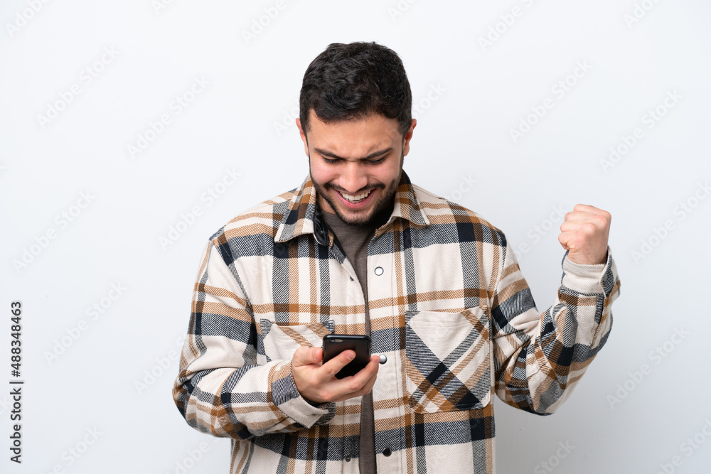 Young Brazilian man isolated on white background surprised and sending a message Young Brazilian man isolated on white background surprised and sending a message