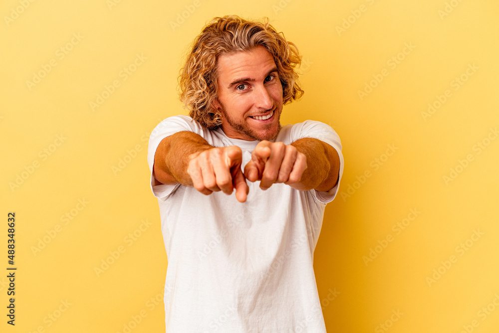 Young caucasian man isolated on yellow background pointing to front with fingers. Young caucasian man isolated on yellow background pointing to front with fingers.
