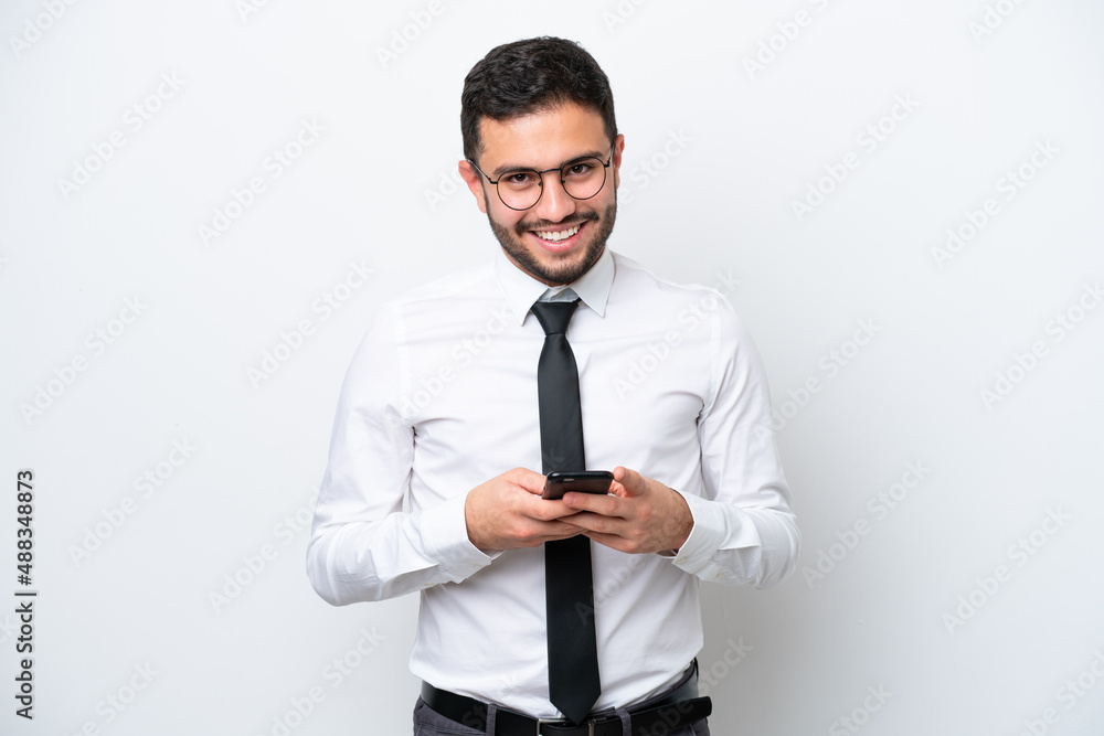 Business Brazilian man isolated on white background sending a message with the mobile Business Brazilian man isolated on white background sending a message with the mobile