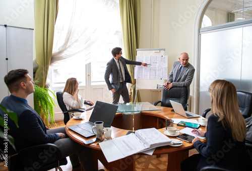 Successful business professionals presenting new project while working together with colleagues in the modern office
