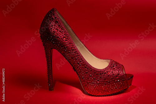 red women's shoes with high heels. red background.