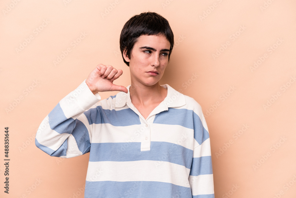 Young caucasian woman isolated on beige background showing a dislike gesture, thumbs down. Disagreement concept. Young caucasian woman isolated on beige background showing a dislike gesture, thumbs down. Disagreement concept.