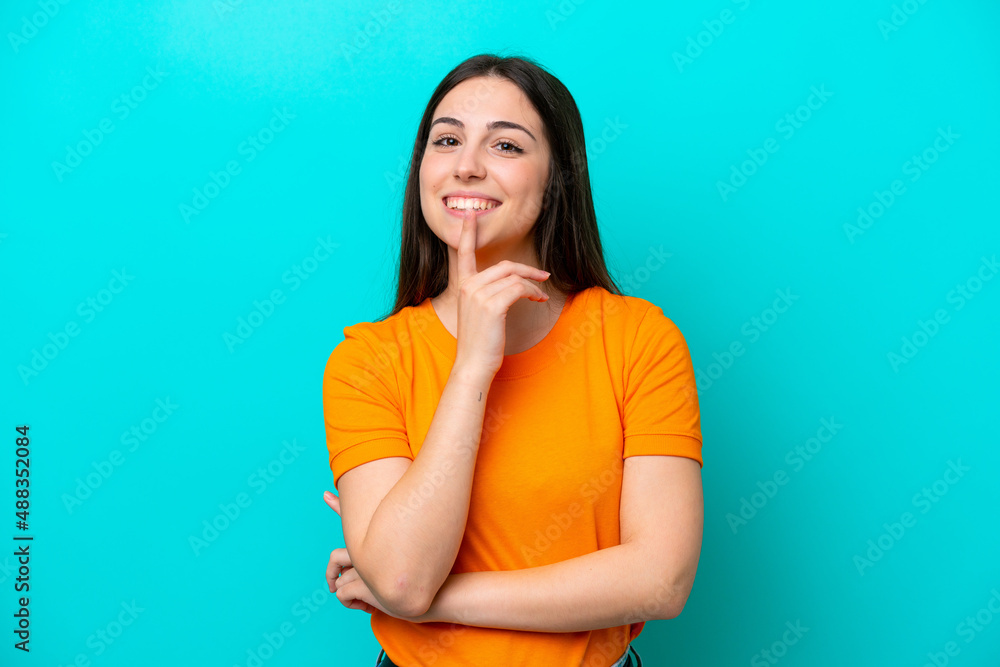 Young caucasian woman isolated on blue background showing a sign of silence gesture putting finger in mouth Young caucasian woman isolated on blue background showing a sign of silence gesture putting finger in mouth