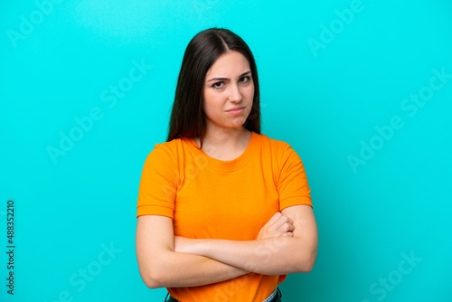 Young caucasian woman isolated on blue background feeling upset