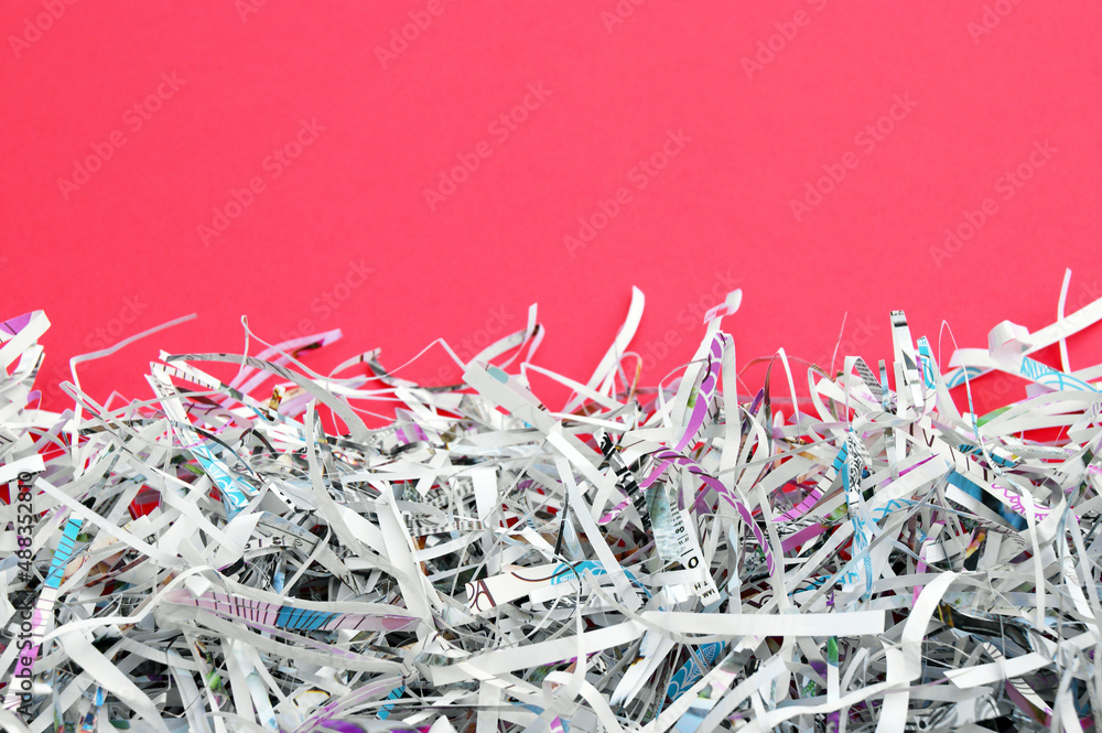 The white shredded paper on red background. The white shredded paper on red background.