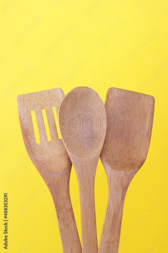 A set of bamboo dishes on a bright yellow background. A set of bamboo dishes on a bright yellow background.