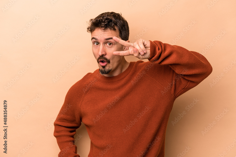 Young caucasian man isolated on beige background dancing and having fun. Young caucasian man isolated on beige background dancing and having fun.