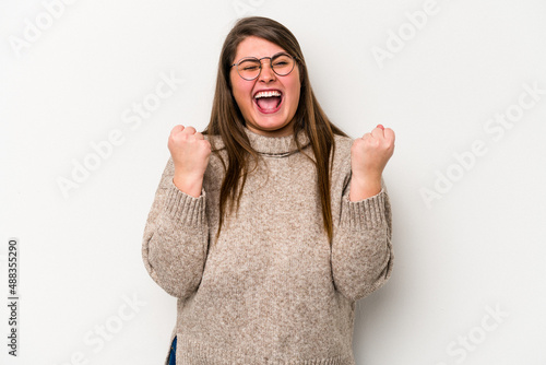 Young caucasian overweight woman isolated on white background cheering carefree and excited. Victory concept.