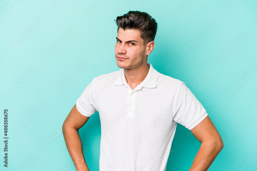 Young caucasian man isolated on blue background confused, feels doubtful and unsure. Young caucasian man isolated on blue background confused, feels doubtful and unsure.