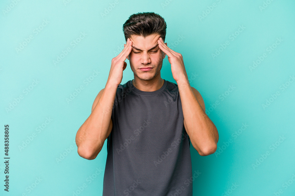 Young caucasian man isolated on blue background touching temples and having headache. Young caucasian man isolated on blue background touching temples and having headache.