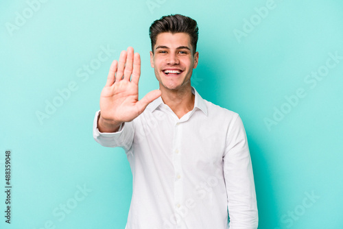Young caucasian man isolated on blue background smiling cheerful showing number five with fingers. © Asier