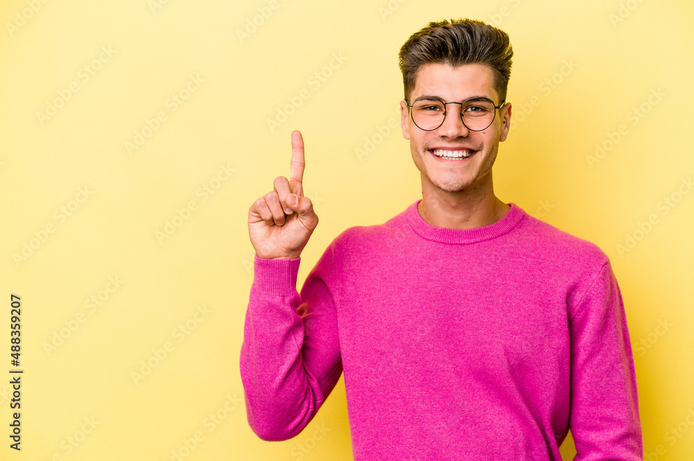 Young caucasian man isolated on yellow background showing number one with finger. Young caucasian man isolated on yellow background showing number one with finger.