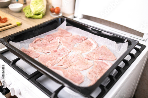 Chops. Woman hands put fresh turkey steaks meat on oven tray