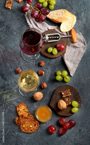 Red wine with appetizers on gray background.