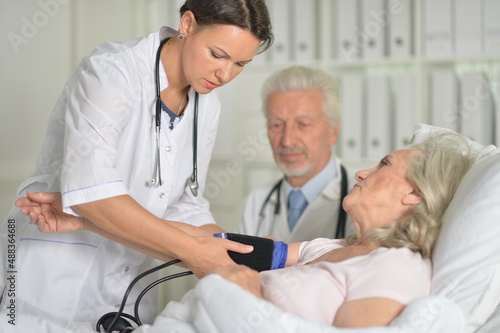 Senior woman in hospital with caring doctors