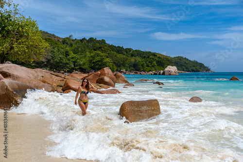 Adult woman wearing a bikini and posing at the Anse Lazio beach in Seychelles photo