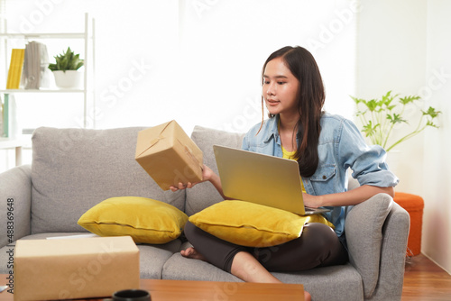 Asian woman freelance or online shop owner seller ecommerce marketing check store and order on internet website work from home in shopping online website or social media © KomootP