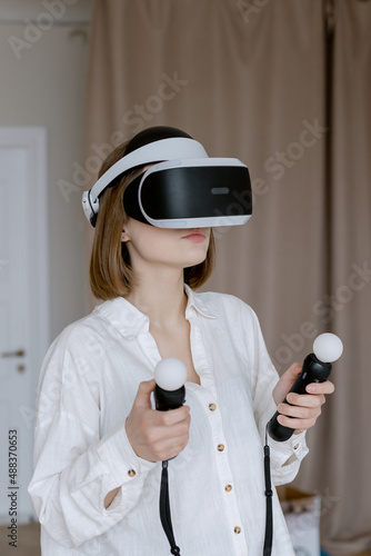 Beautiful woman touching the air during VR experience Joystick in female hand Games at home
