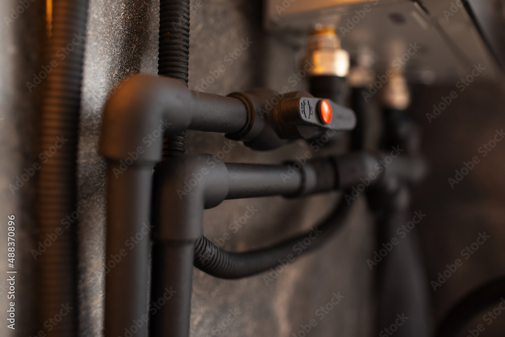 Close-up of black connected polypropylene pipes and tap. Close-up of black connected polypropylene pipes and tap.