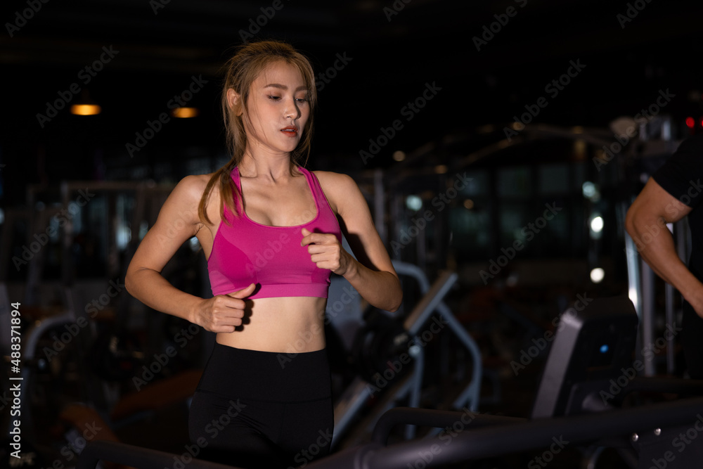 Young asian women in sportswear running on treadmill at gym
