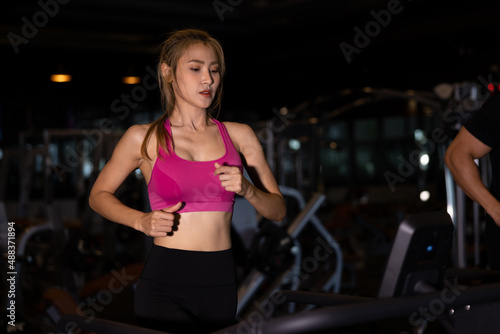 Young asian women in sportswear running on treadmill at gym
