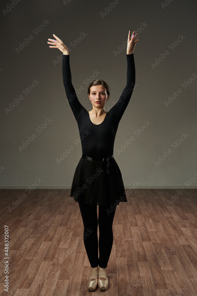 the dancer gracefully holds her hands above her head, spreading her hands in different directions. beauty elegance, grace of dance.