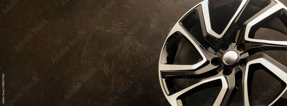 new stylish cool alloy wheel on the tire dark textured background ...