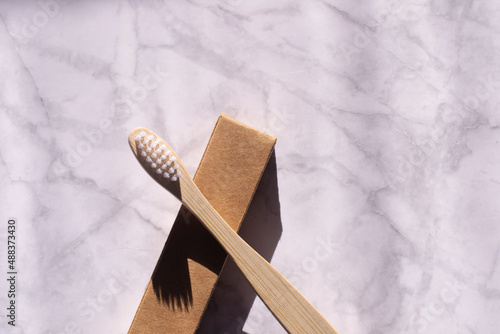Wallpaper Mural Wooden toothbrush on a light marble background. Eco bamboo toothbrush with paper packaging. Plastic free dental care.  Torontodigital.ca