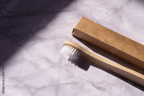 Wallpaper Mural Wooden toothbrush on a light marble background. Eco bamboo toothbrush with cardboard packaging. Plastic free dental care.  Torontodigital.ca