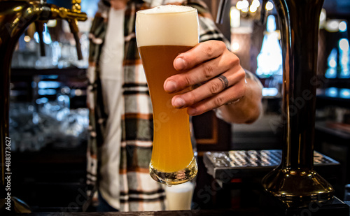 Stampa su tela bartender pouring a draught beer in glass serving in a bar or pub