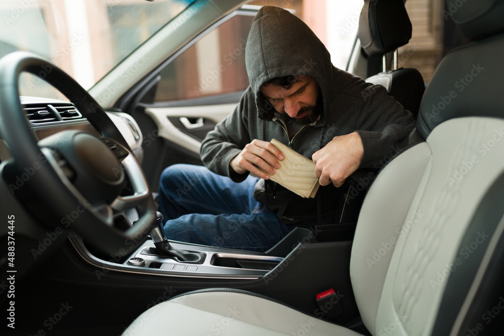 Hispanic man stealing from a car