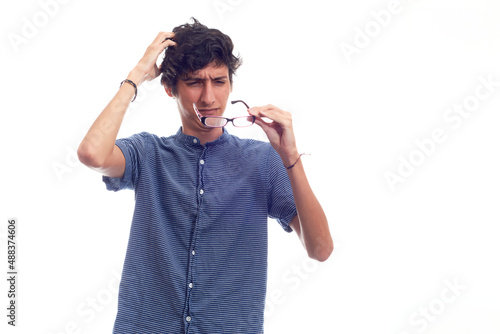 Man with glasses straining his eyes because he can't see well. photo