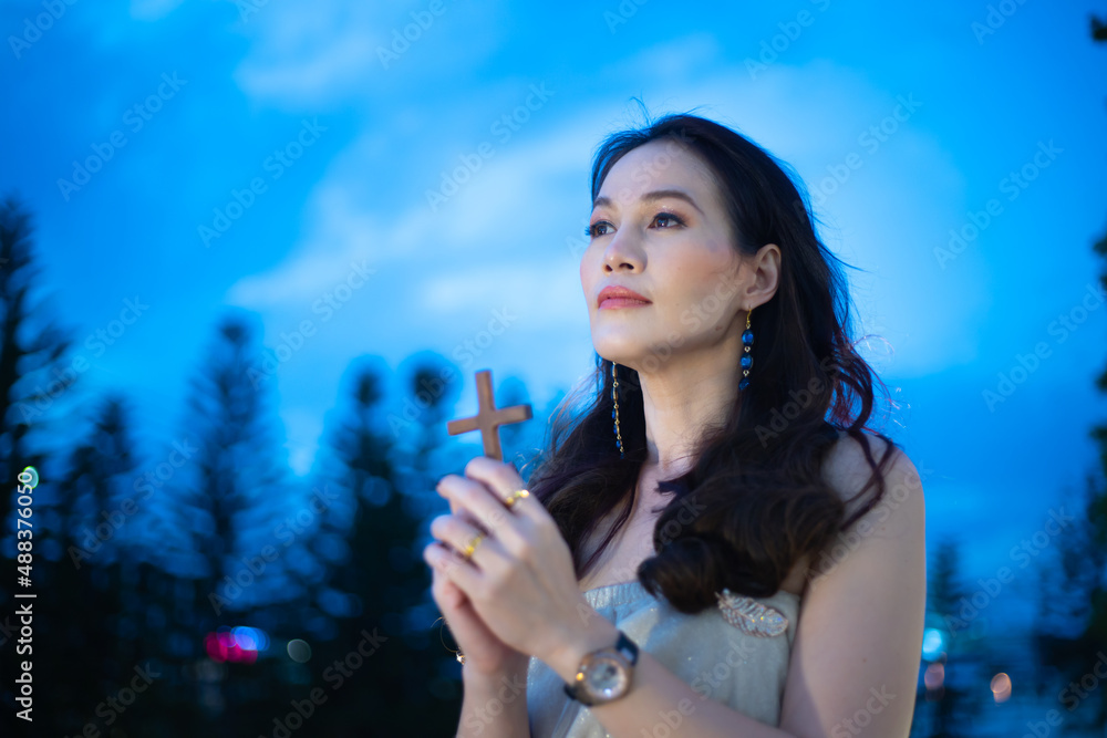 Woman hands pray with wooden cross outdoor. Concept for faith, spirituality and religion. Woman hands pray with wooden cross outdoor. Concept for faith, spirituality and religion.