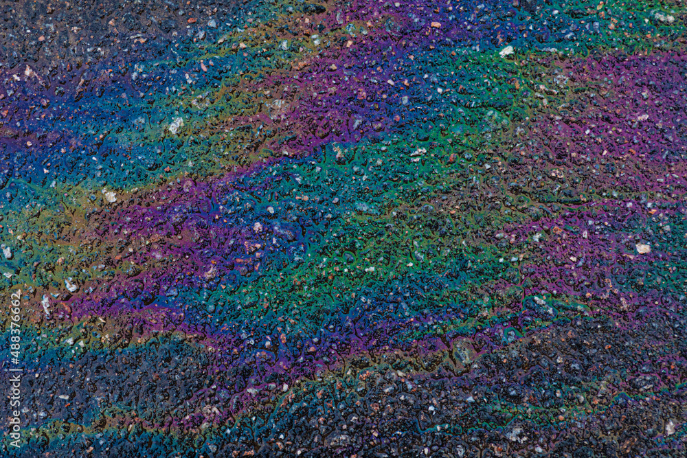 Fototapeta premium Bright, vivid and colorful backgrond or backdrop of oil, gas or petrol rainbow spots on asphalt or bitumen surface