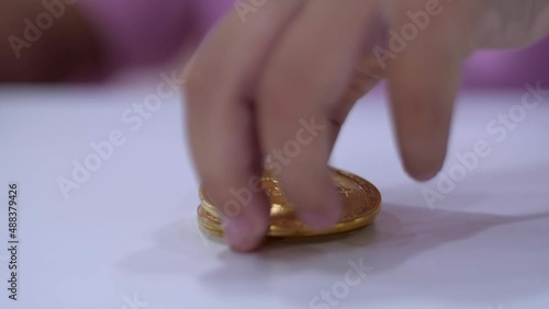Slow motion scene of a 5-year-old Asian girl collecting bitcoins. fun at the table
