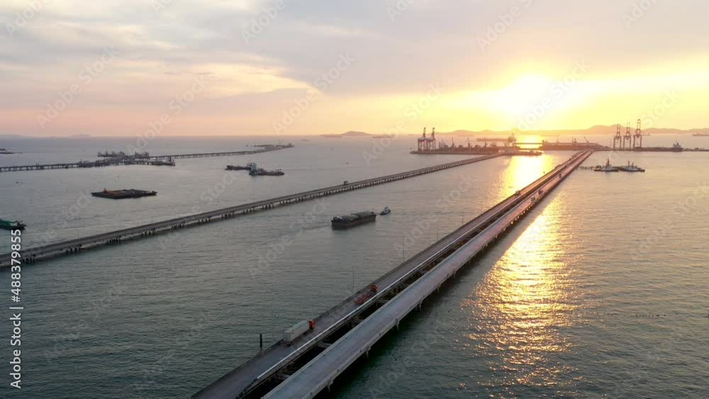 aerial view transport vehicle runs on a bridge in the middle of the sea during sunset aerial view transport vehicle runs on a bridge in the middle of the sea during sunset