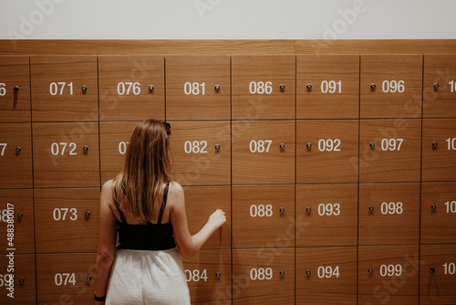 a woman opens a left-luggage office to pick up her things photo