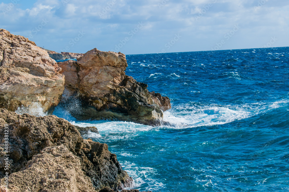 Sea waves splashing against the rocks at Għar Lapsi