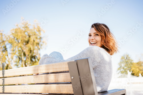 Joyful carefree woman laughing as she relaxes outdoors