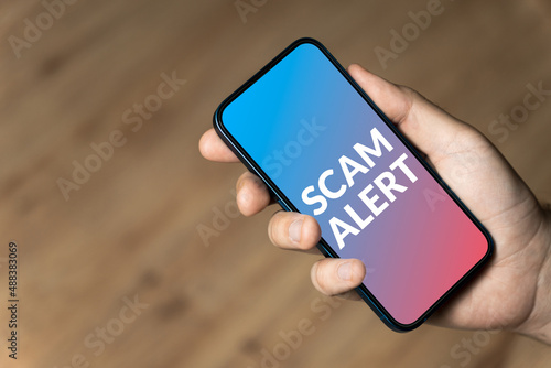Scam alert - hand holding a phone