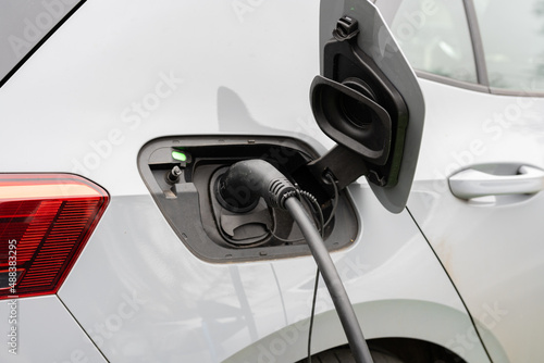 Electric car charging at plug in charge station in a public car park in Suffolk, UK