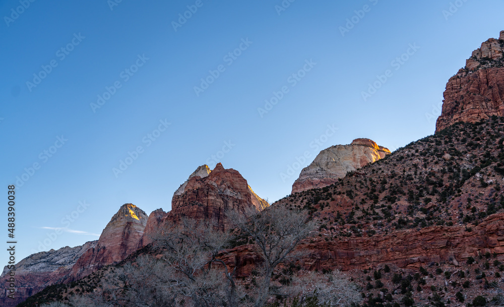 Fototapeta premium Looking up to Large Mountains Peak During Sunrise In Zion National Park