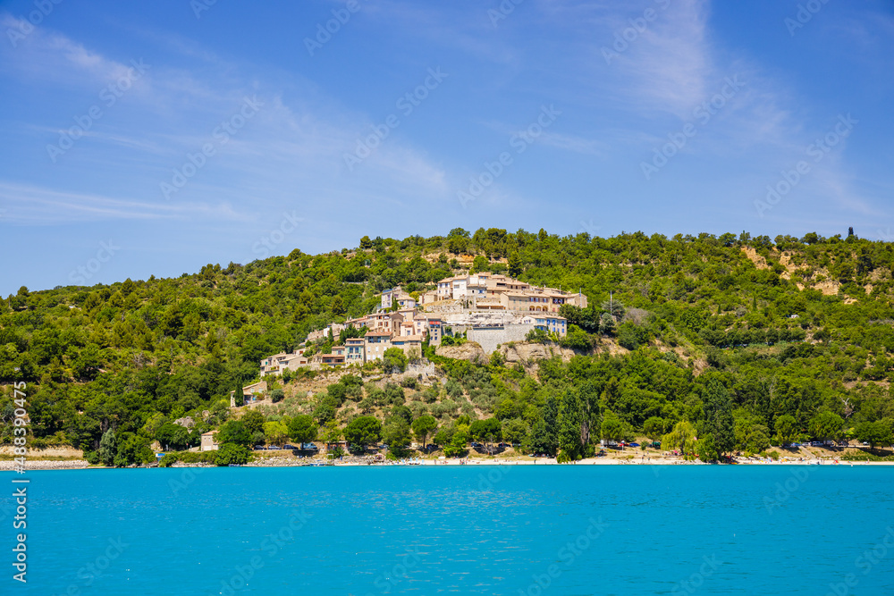 Village of Sainte-Croix-du-Verdon perched on a hill seen from the Lake of Sainte-Croix in Alpes-de-Haute-Provence, France