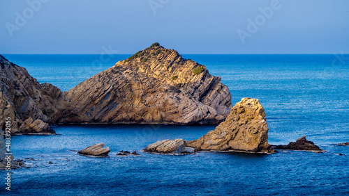 Acantilados rocosos al atardecer sobre un mar y cielo azul