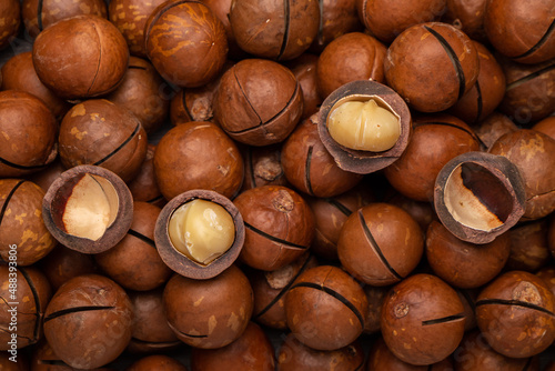 whole and cracked macadamia nuts background