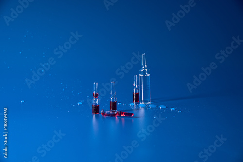 Medicines with red liquid lie on blue background  photo