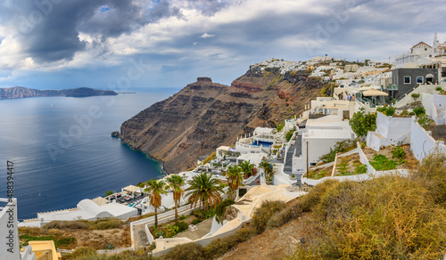 Picturesque view of the famous Greek resort of Thira, Santorini island. Traditional village with white houses with blue domes over Caldera, Aegean Sea. Greece. Summer holidays.